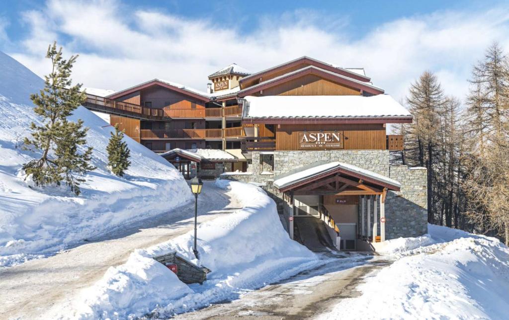 un lodge de ski dans la neige avec des routes enneigées dans l'établissement Plagne Villages, Charmante Résidence de Tourisme 4 Etoiles, à Plagne Villages