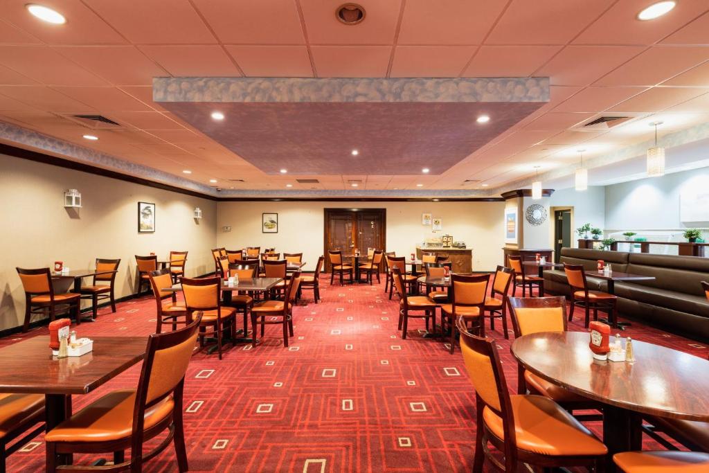 a dining room with wooden tables and chairs at Crowne Plaza Newark Airport by IHG in Elizabeth