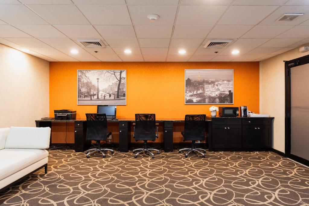 a office with a desk and chairs and a couch at Crowne Plaza Newark Airport by IHG in Elizabeth
