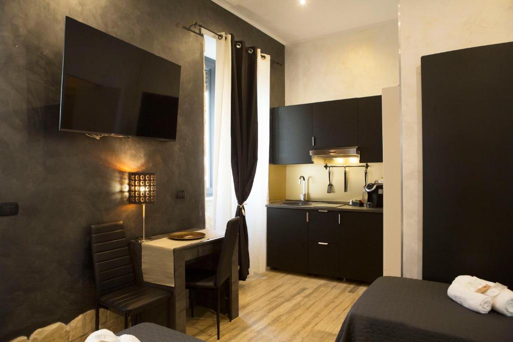 a hotel room with a bedroom with a desk and a kitchen at Jadore Monic in Rome