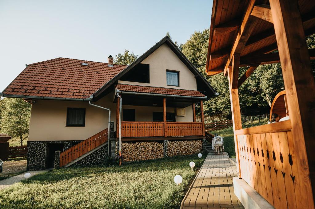 una pequeña casa con porche y valla en Súgópatak Kulcsosház, en Izvoare