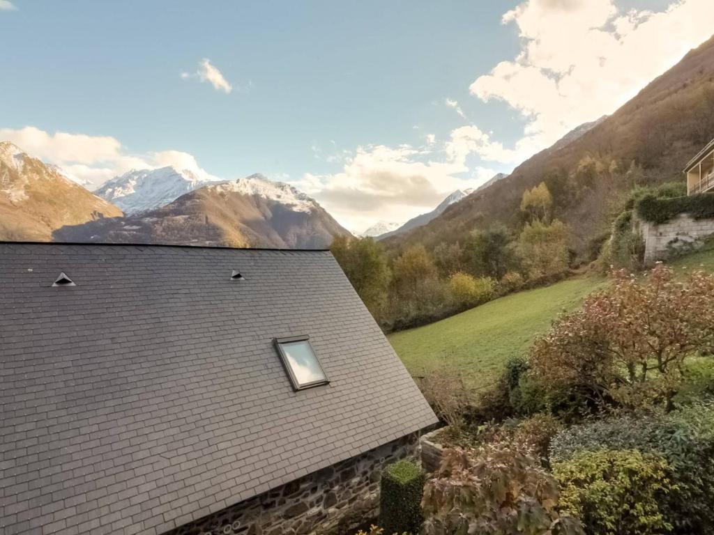 une fenêtre sur le toit d'une maison avec des montagnes en arrière-plan dans l'établissement Appartement Sazos, 3 pièces, 4 personnes - FR-1-402-8, à Sazos