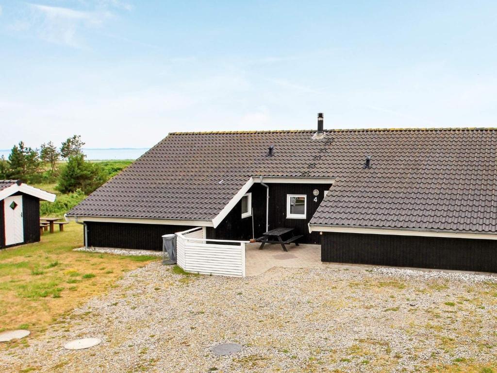 ein Haus mit einem schwarzen Dach und einem Hof in der Unterkunft 14 person holiday home in L gst r in Trend