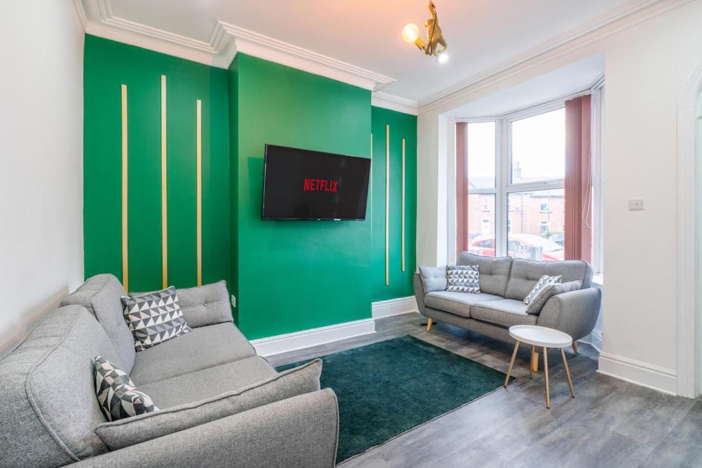 a living room with two couches and a green wall at Stylish 3 Bed - Entire House- Near City Ctr & SUFC in Sheffield