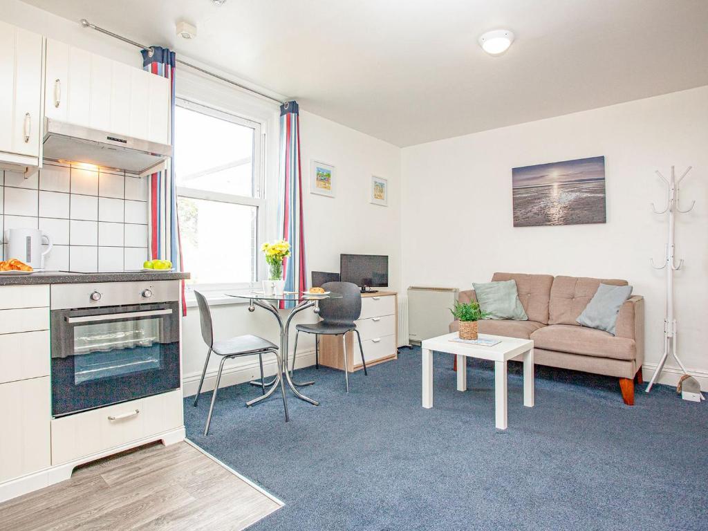 ein Wohnzimmer mit einem Sofa und einem Tisch in der Unterkunft Apartment Ten - Uk39862 in Paignton