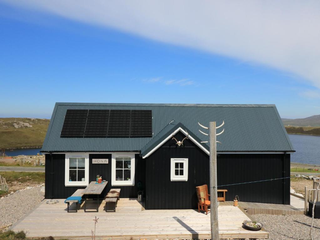 a black house with solar panels on the roof at Hona in Mangersta