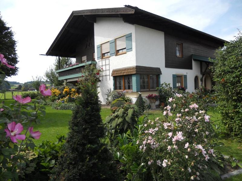 a large white house with flowers in front of it at Ferienwohnung Edmeier in Bernau am Chiemsee