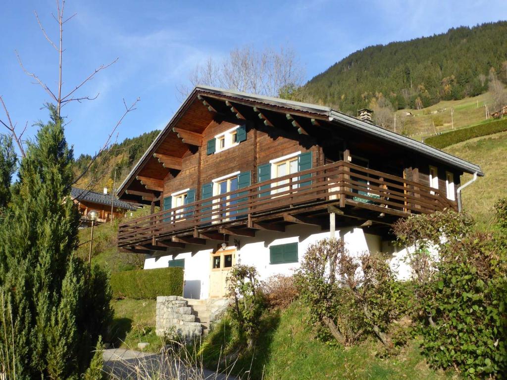 Cette grande maison en bois dispose d'un balcon sur une colline. dans l'établissement Chalet cosy 11 pers avec wifi, lave-vaisselle & lave-linge - FR-1-342-229, à Beaufort