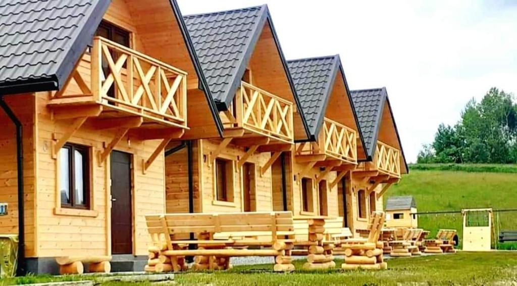 uma cabana de madeira com um banco à frente em Motylowe Wzgórze Apartamenty Zawóz em Zawóz