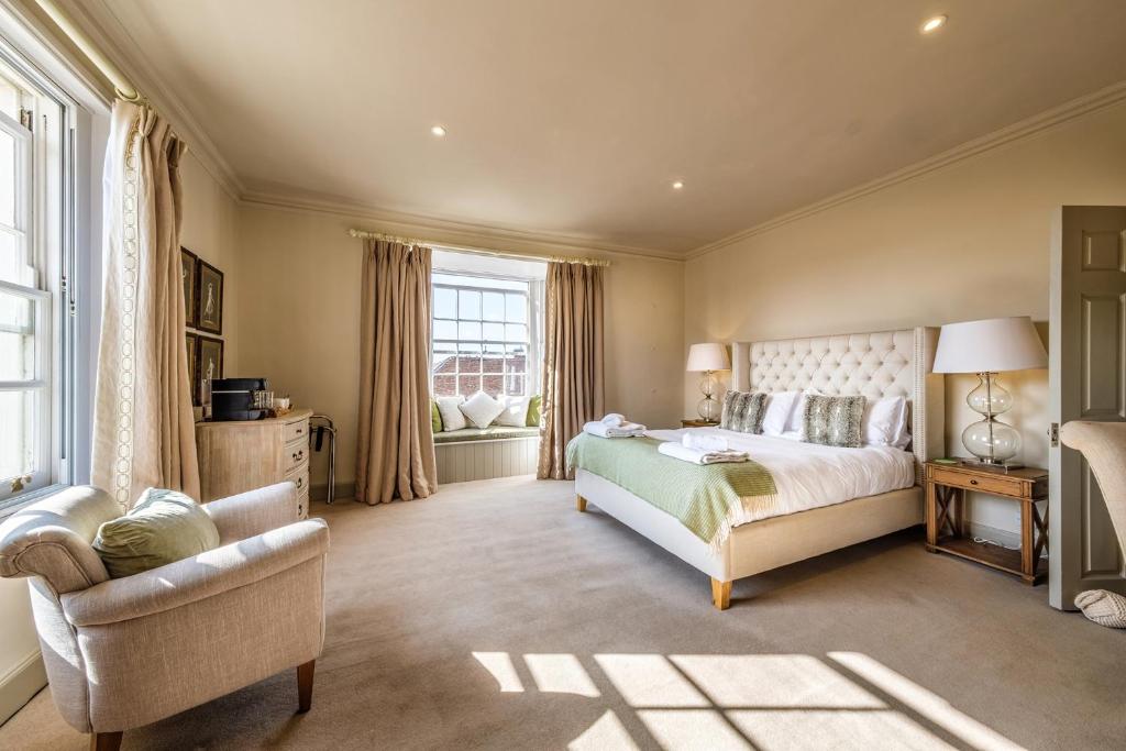 長梅爾福德的住宿－The Black Lion, Long Melford，卧室配有床、椅子和窗户。