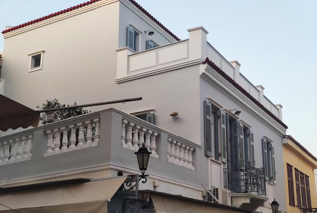 Edificio blanco con balcón y luz de la calle en Elayio Old Town en Tinos Town