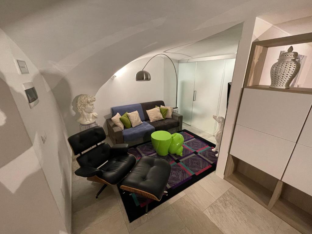 een woonkamer met een bank en stoelen bij Loft “Cinema Galleria” in Bari