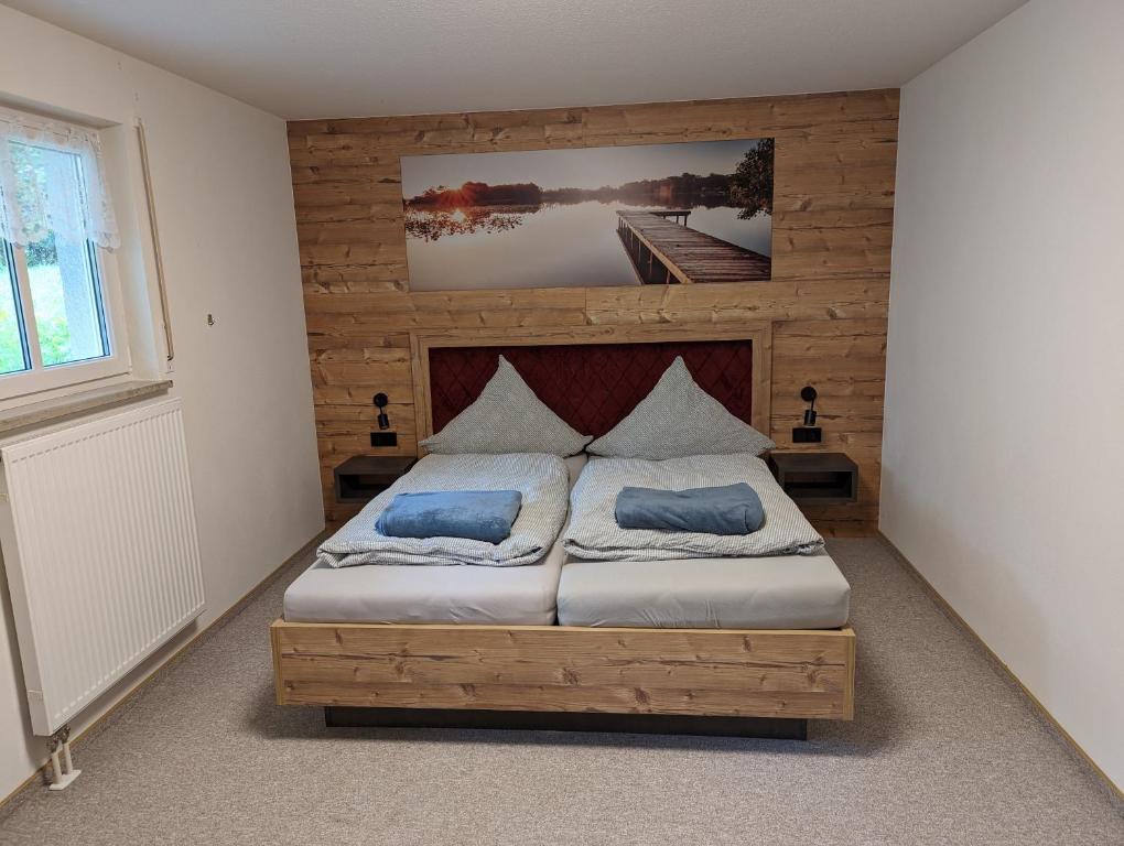 a bedroom with a bed with two blue pillows at FeWo Grenzenlos in Ramsberg in Pleinfeld