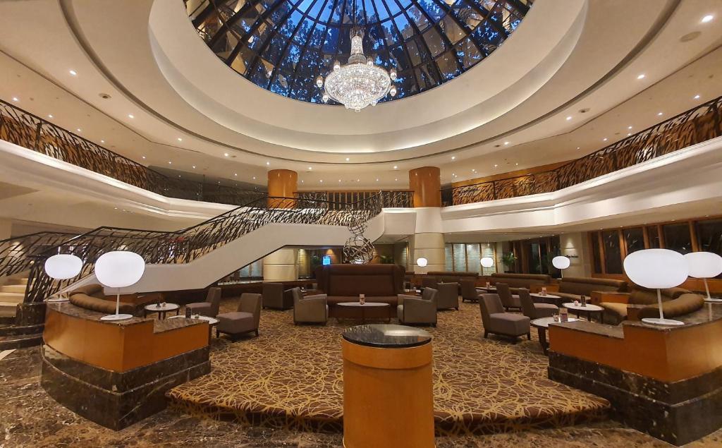 eine Hotellobby mit einer Treppe und einer großen Decke in der Unterkunft Sunway Putra Hotel Kuala Lumpur in Kuala Lumpur