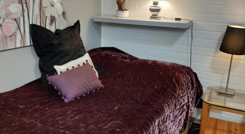Una cama con una manta púrpura y almohadas. en Pikkukoti Lemmikki, en Keuruu