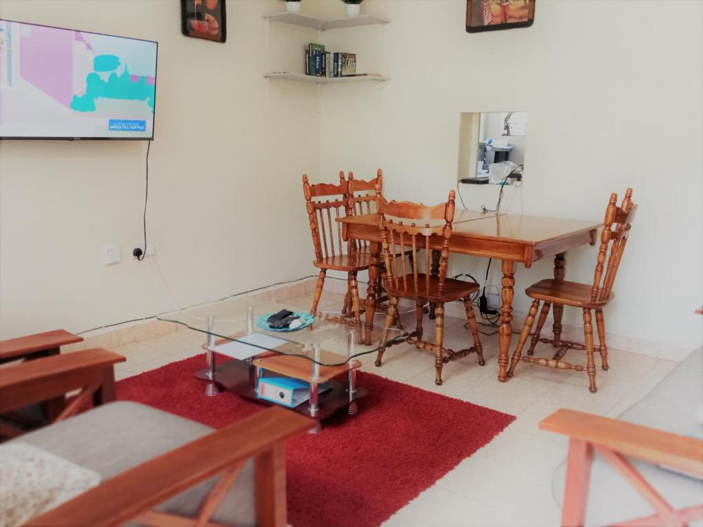 Twende Nanyuki Homes في نانيوكي: غرفة طعام مع طاولة وكراسي
