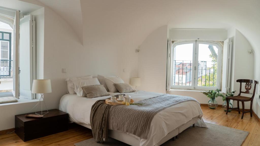 リスボンにあるCasa do Castelo - Superior House by Home With a Viewの白いベッドルーム(大型ベッド1台、窓2つ付)