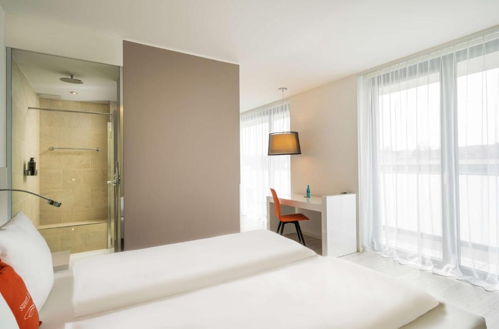 a hotel room with a bed and a mirror at The Rilano Hotel Cleve City in Kleve