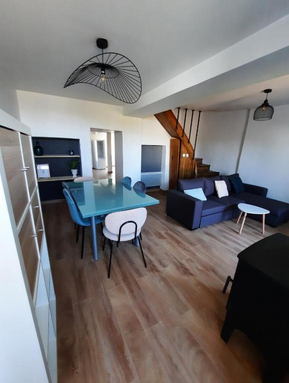 a living room with a blue table and a couch at Maison centre saint Quentin en mauges in Saint-Quentin-en-Mauges