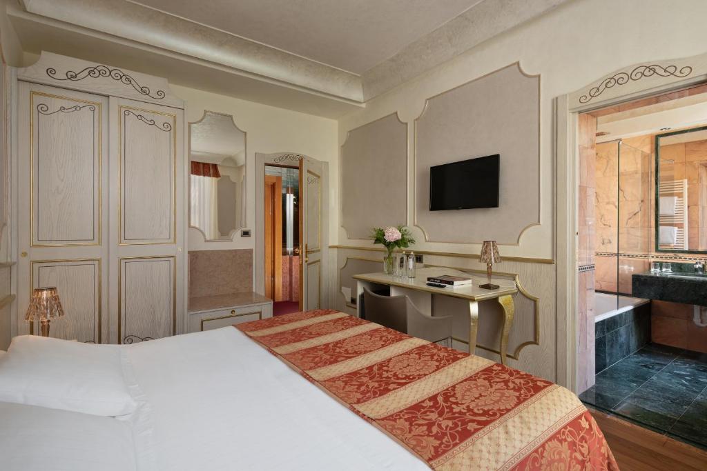 Postel nebo postele na pokoji v ubytování Hotel Colomba d'Oro