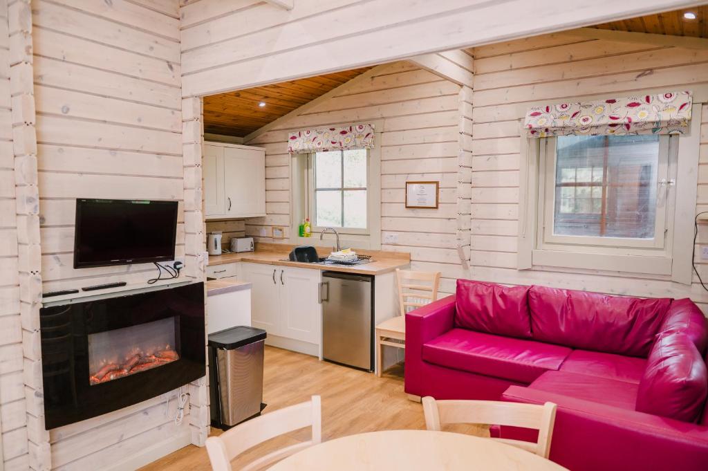 ein Wohnzimmer mit einem roten Sofa und einer Küche in der Unterkunft The Jonas Centre in Leyburn