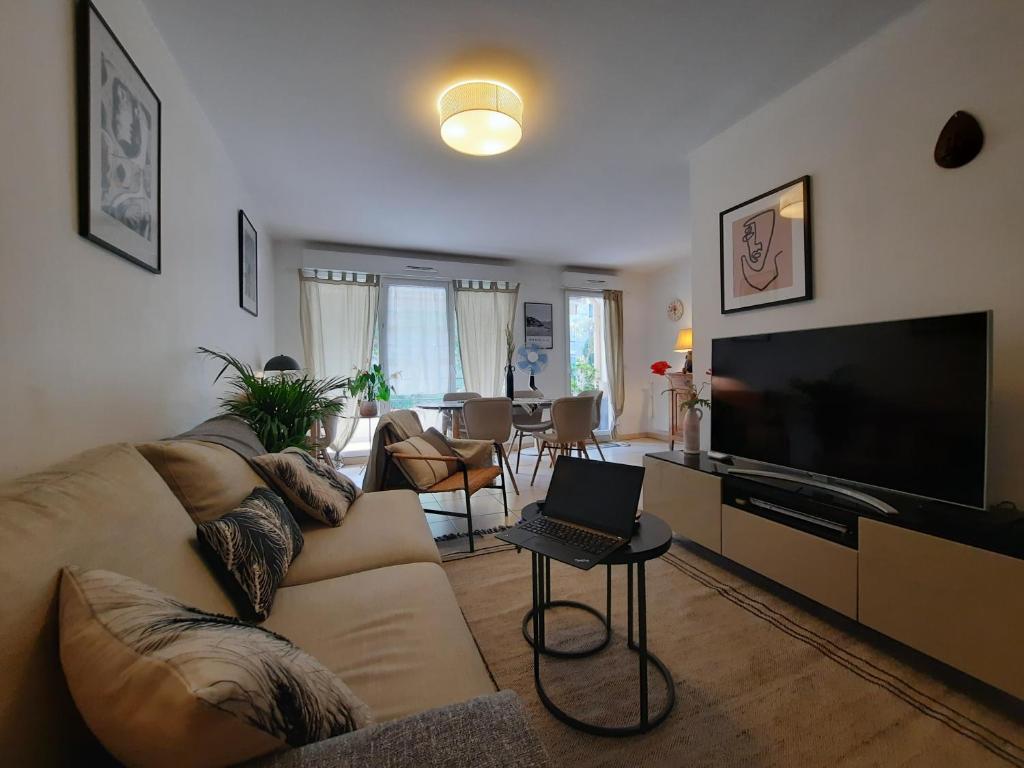 a living room with a couch and a flat screen tv at Pytheas Carré d'Or in Marseille