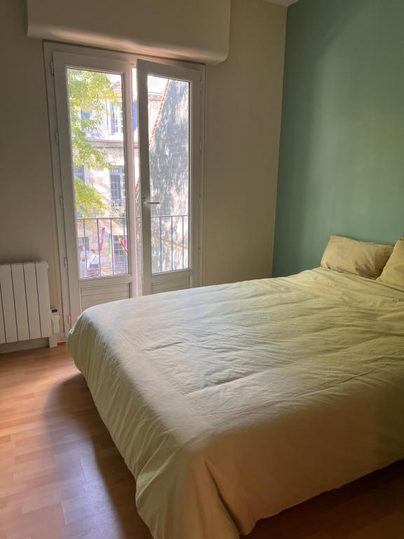 - une chambre avec un grand lit et une fenêtre dans l'établissement Appart'Alencon, à Aleçon