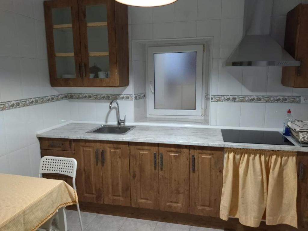 eine Küche mit einem Waschbecken und einem Fenster in der Unterkunft Fuentinueva in Ampuero