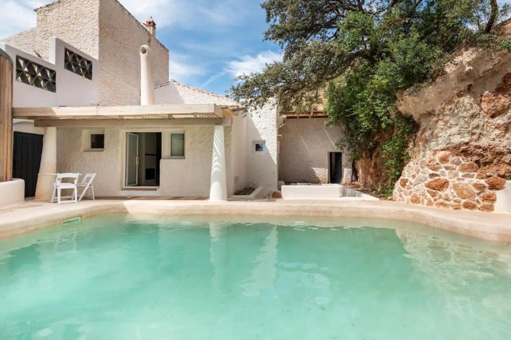 uma villa com piscina em frente a uma casa em Apartamento Caolin Rocabella em El Chorro