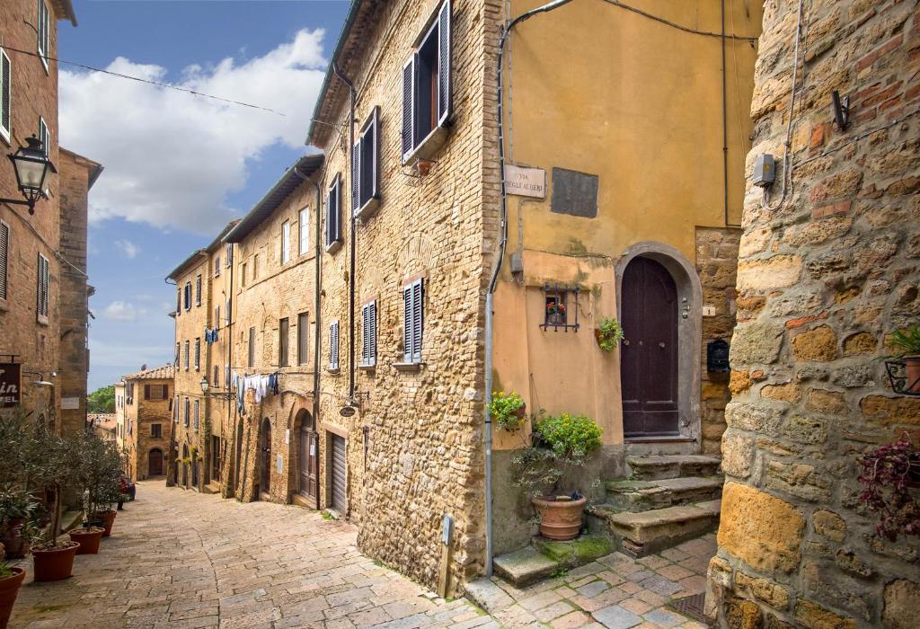 um beco numa cidade velha com edifícios de pedra em Residenza Porta all'Arco em Volterra