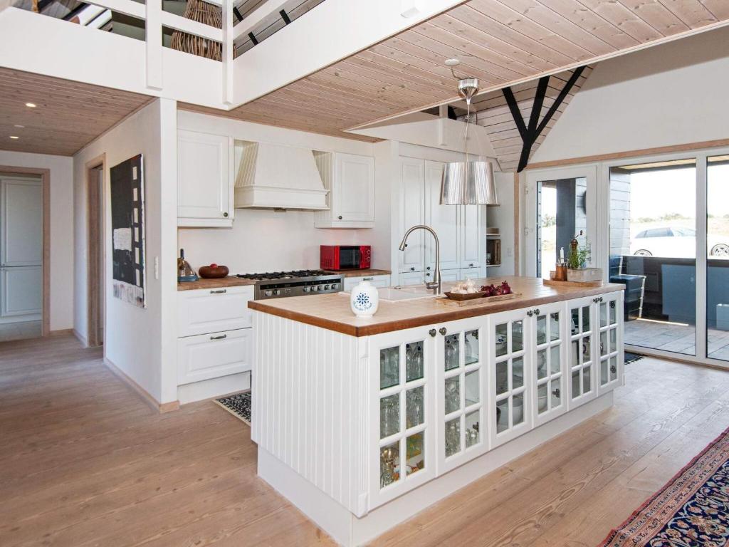 eine Küche mit weißen Schränken und einer Kücheninsel in der Unterkunft Holiday home Fanø CLXXVIII in Fanø