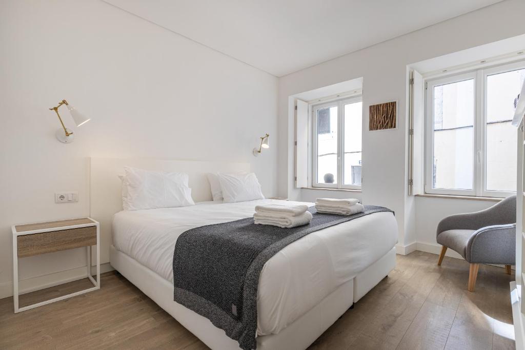 1 dormitorio blanco con 1 cama blanca y 1 silla en Garcia 28, en Lisboa
