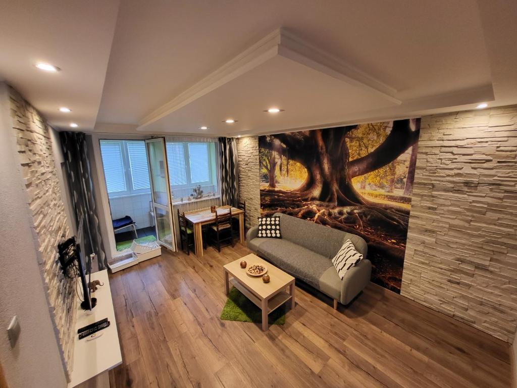 sala de estar con sofá y mural en el árbol en Apartmán George, en Bratislava