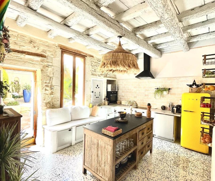 uma cozinha com um frigorífico amarelo e um balcão em La Maison du Trident en Camargue Piscine et Jacuzzi em Vauvert