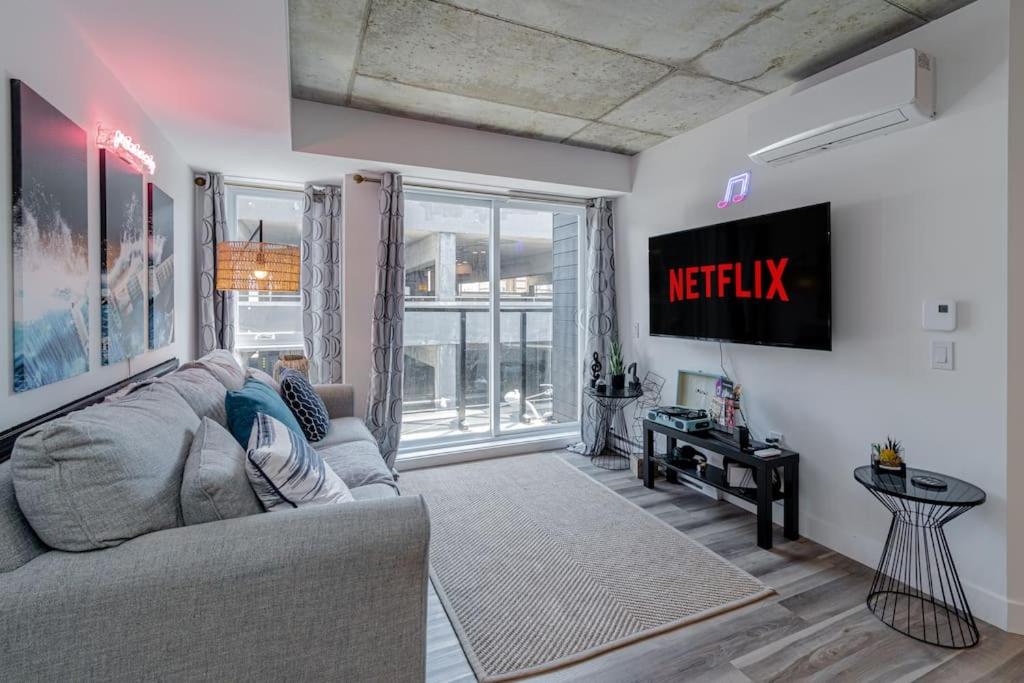 a living room with a couch and a tv at NOUVEAU - CONDO 2CH - VIEUX-QUÉBEC in Quebec City