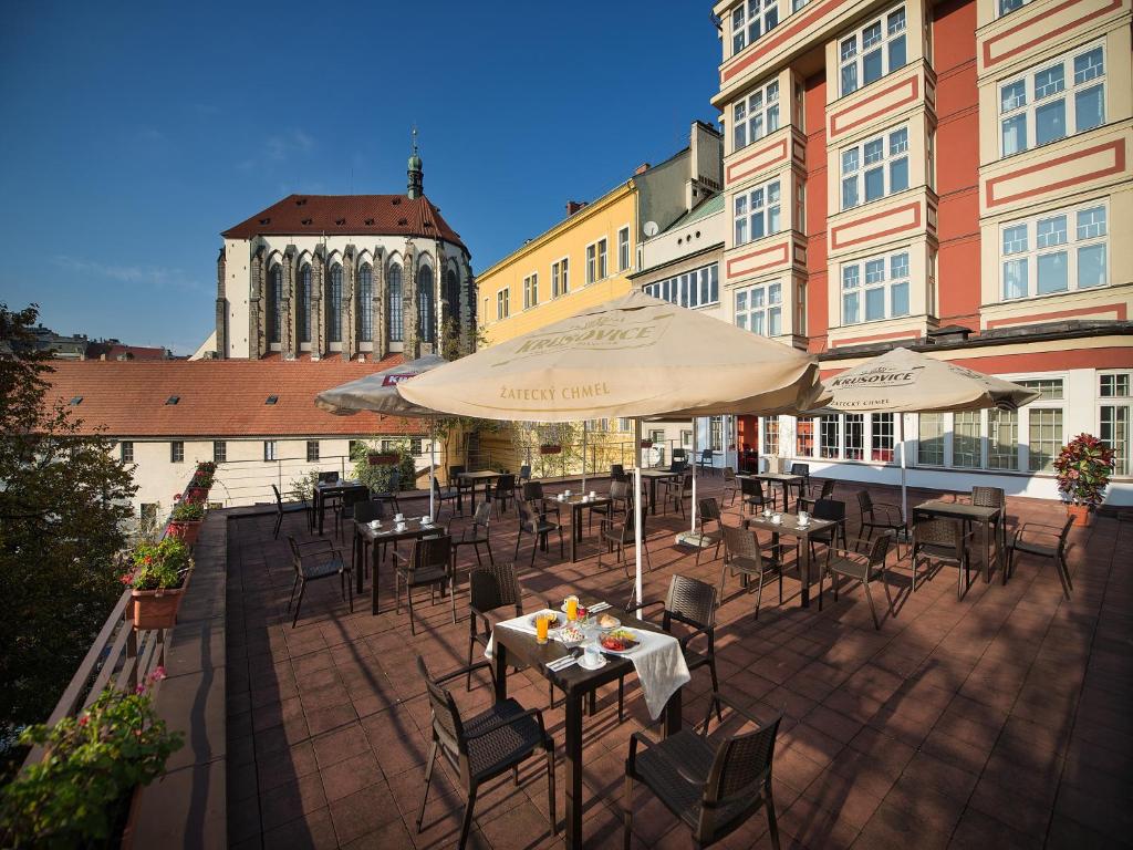 a patio with tables and chairs and umbrellas at EA Hotel Julis in Prague