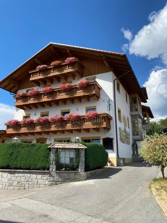 a building with flowers on the balconies on it at Landgasthof Brandtner Wirt in Langdorf