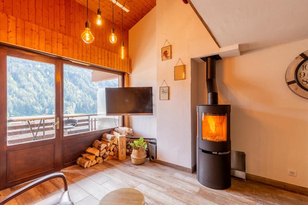 a fireplace in a room with a view of a mountain at Le Beauregard in Le Grand-Bornand