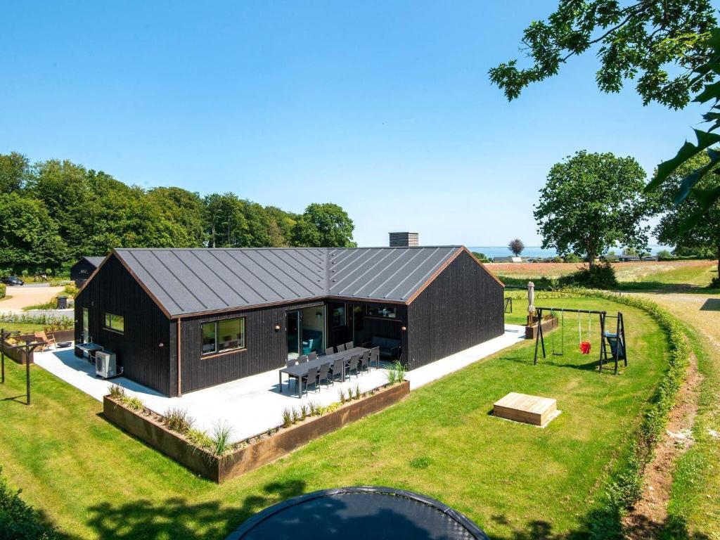 - une vue sur une maison noire dotée d'une aire de jeux dans l'établissement 12 person holiday home in Haderslev, à Haderslev