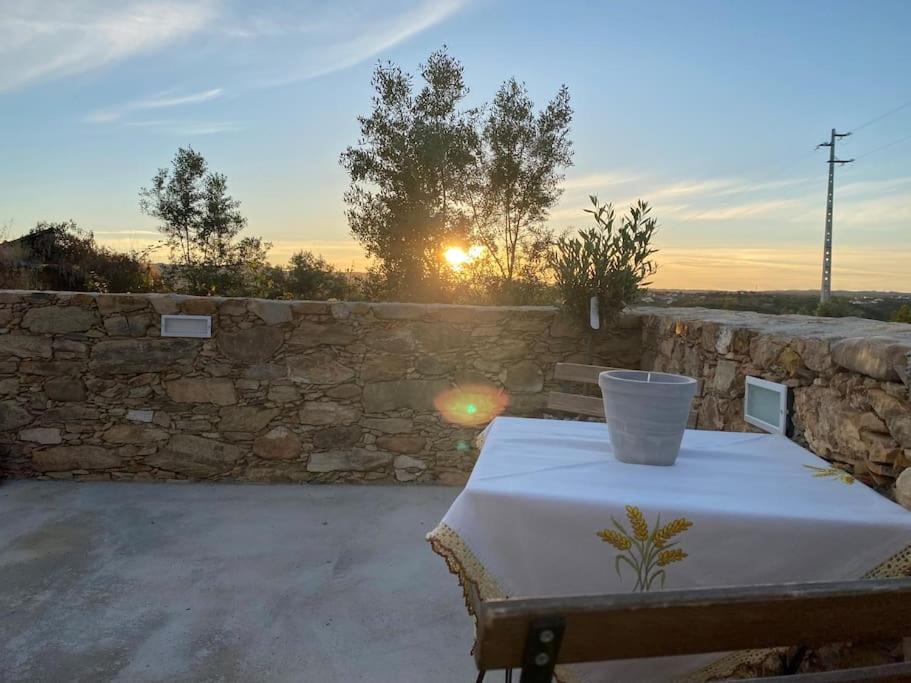 una mesa con un mantel blanco sobre una pared de piedra en Casa do Calhau - AL en Hombres