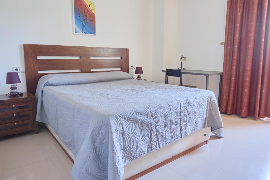 Un dormitorio con una cama con una manta azul. en Alojamiento Particular en Almería