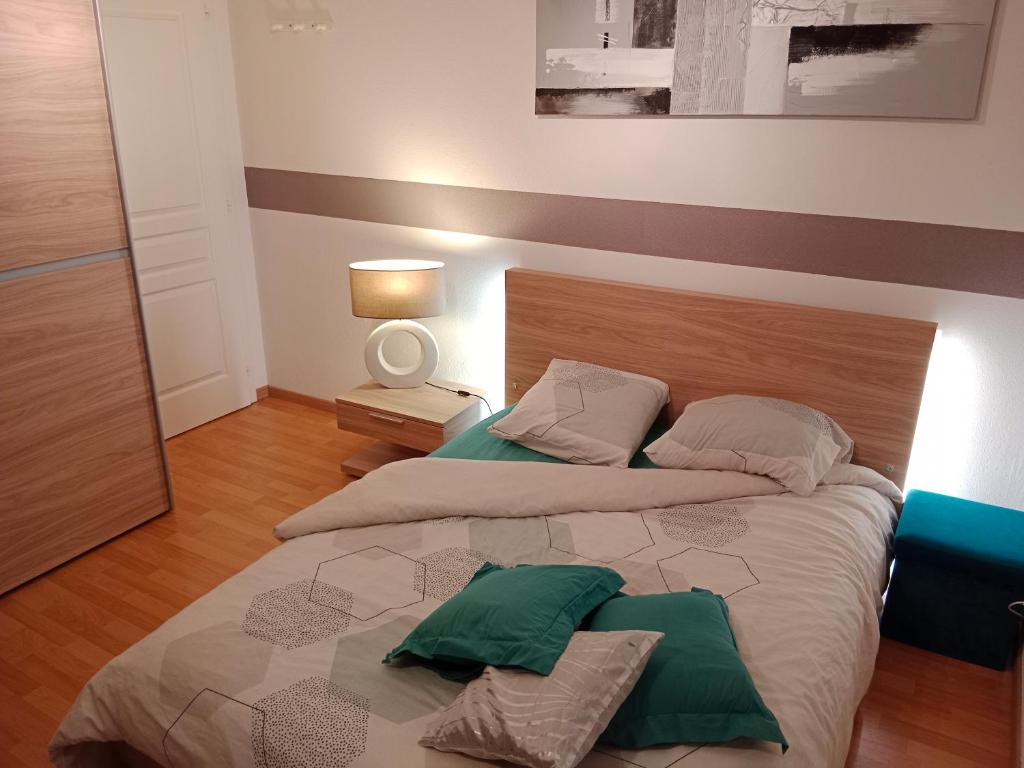 1 dormitorio con 2 camas y almohadas verdes en Chambre #1 dans appartement partagé - Proche des Vosges, en Thann