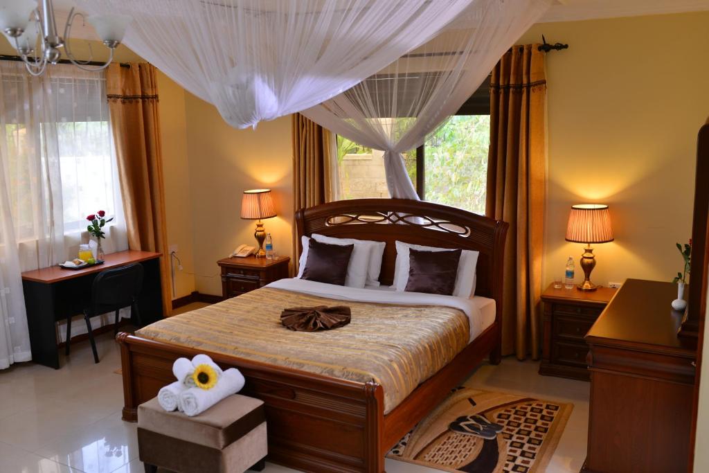 a bedroom with a large bed and a window at Royal Victoria House in Kampala