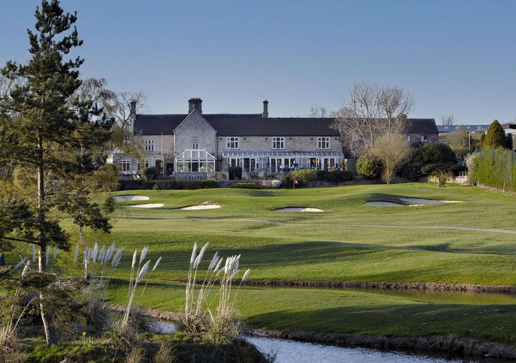 a view of a golf course with a large house at Horsley Lodge in Derby