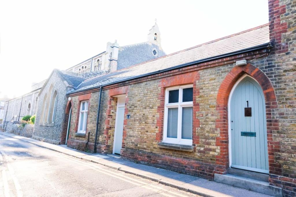 un edificio de ladrillo con una puerta azul en una calle en Old School Mews By The Sea Broadstairs en Broadstairs