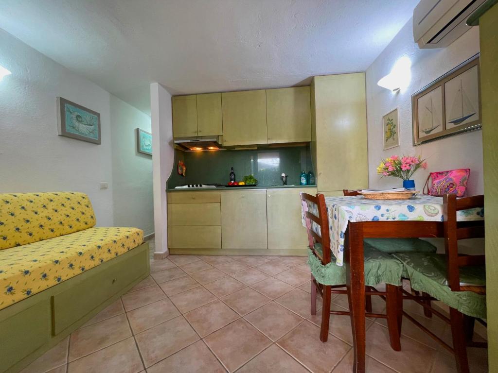 a living room with a table and a kitchen at Sardegna Beach Cala Reale in Santa Marinella