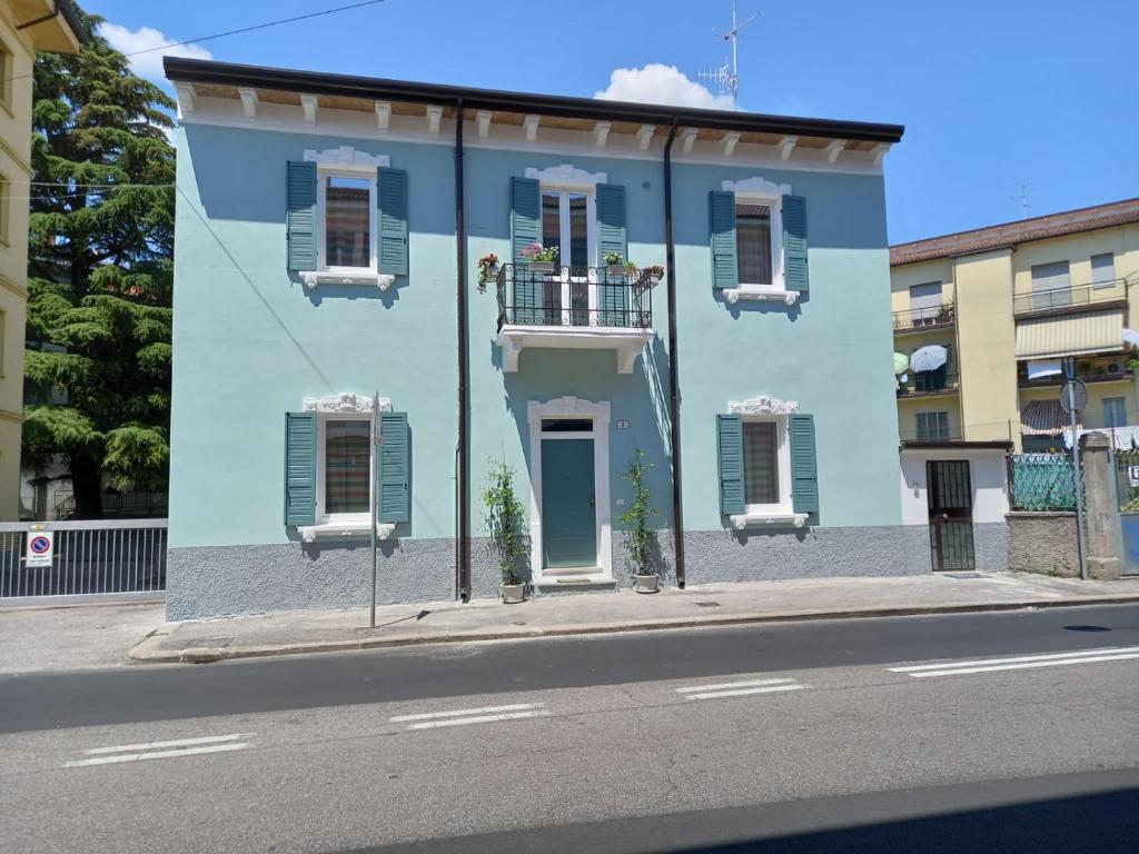 a blue building with white windows and a balcony at Mercante In Fiera in Verona
