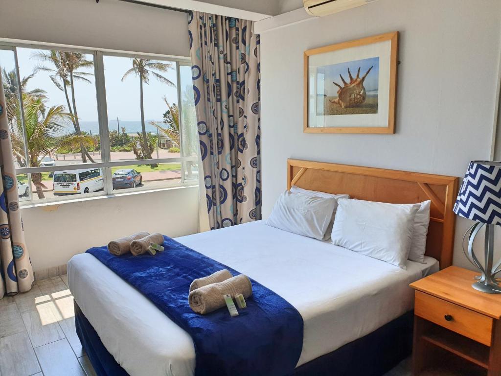 a bedroom with a bed with two teddy bears on it at Gooderson Leisure Silver Sands 2 Self Catering and Timeshare Lifestyle Resort in Durban