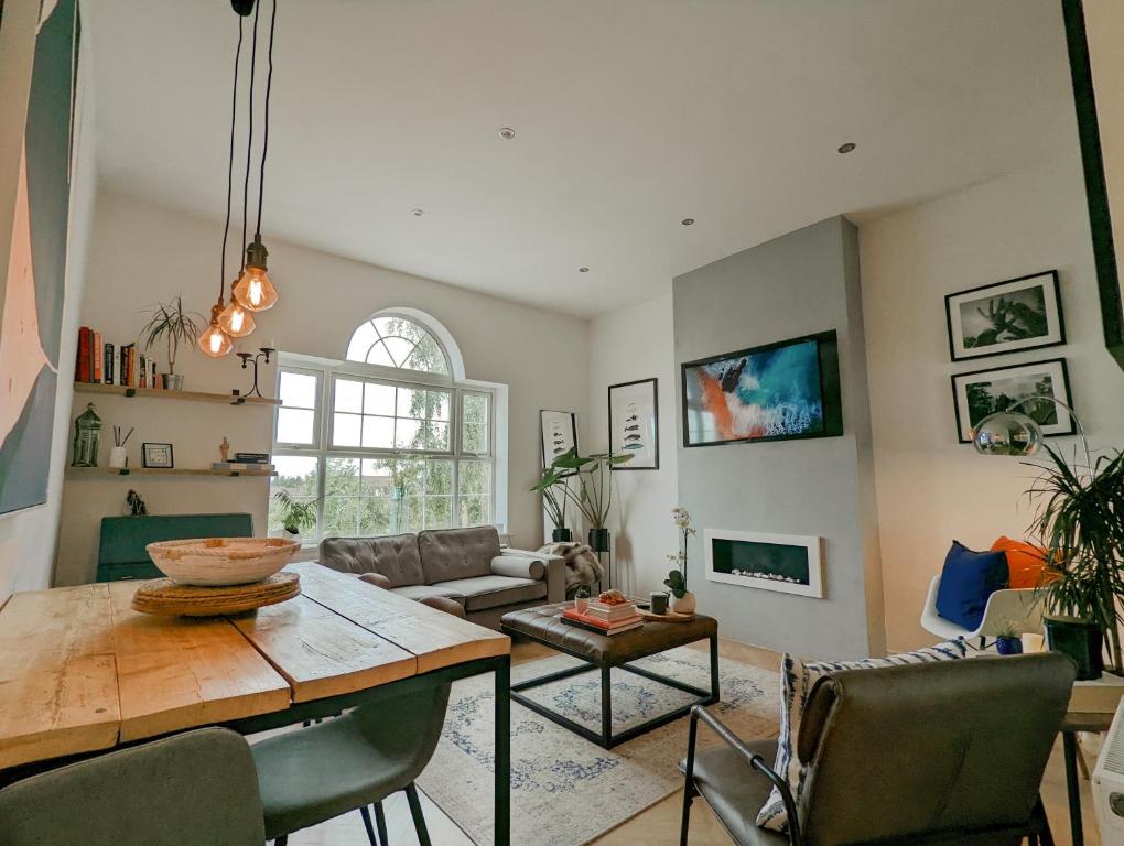 uma sala de estar com uma mesa e um sofá em Spacious, Mid-Century 1 bedroom Apartment em Quedgeley
