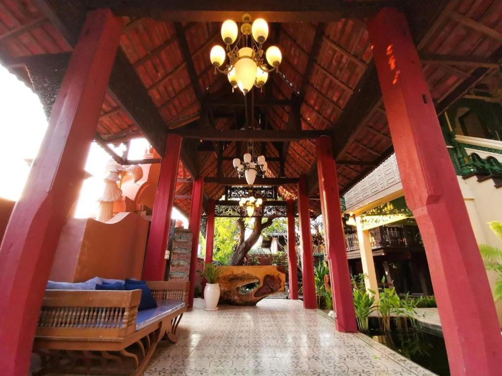 a building with red columns and a chandelier at DONPIN8-Timeless House Chiang Mai in Chiang Mai